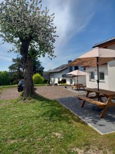 a picnic table and umbrella next to a caravan at Domki Paula in Kudowa-Zdrój