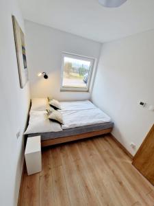 a small bedroom with a bed and a window at Domki Paula in Kudowa-Zdrój