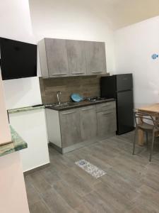 Una cocina con electrodomésticos de acero inoxidable y una mesa. en Casa vacanze Michelina, en Monte di Procida
