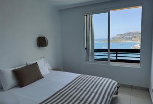 a bedroom with a bed with a view of the ocean at Sand House Doñana - Free beach club access to Kai Club in Patalavaca