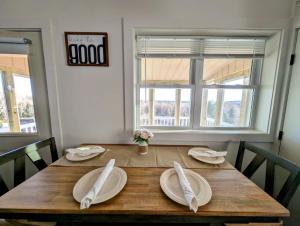 a wooden table with white plates and napkins on it at Acadia Sunset Fishing Cabin #1 family beach 1 dog in Sullivan