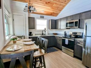 a kitchen with a wooden table and a wooden ceiling at Acadia Sunset Fishing Cabin #1 family beach 1 dog in Sullivan