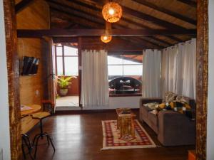 a living room with a couch and a window at Suítes Lar Doce Lar in Lavras Novas