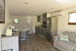 a kitchen and living room with a couch and a table at Le Gecko in Saint-Victor-la-Coste