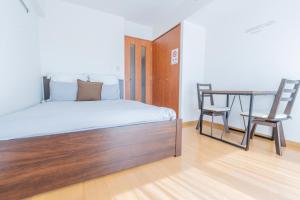una camera da letto con un letto, un tavolo e una sedia di 森下駅徒歩2分 両国 東京スカイツリー直通の快適ステイ Dsx a Tokyo