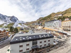a city with buildings and mountains in the background at Studio 5 pers. proche pistes, balcon, casier à skis, non-fumeur - FR-1-404-81 in La Mongie