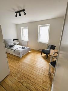 a bedroom with a bed and a desk and a chair at Moderne 3-Zimmer-Wohnung in schönem Altbau in Waiblingen in Waiblingen