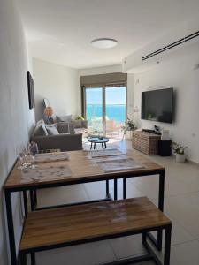 a living room with a table and a couch at Sunset Suite sea&sky in Ashkelon
