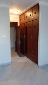 a locker room with wooden cabinets and a tile floor at Leslie's Apartment in Nalakonge