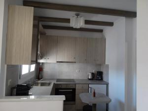 a kitchen with a sink and a stove top oven at Skopelitis Village in Katapola