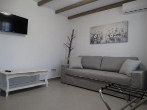 a living room with a couch and a tv at Skopelitis Village in Katapola