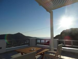a table and chairs on a balcony with a view at Skopelitis Village in Katapola