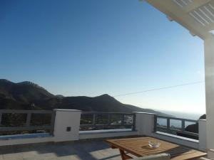 a balcony with a table and a view of the ocean at Skopelitis Village in Katapola