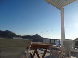 a table and chairs on a balcony with a view at Skopelitis Village in Katapola