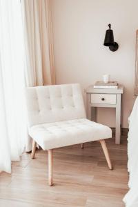 una sedia bianca in una camera da letto con un tavolo di Villas Ensueño - Valle De Guadalupe a San Antonio de las Minas
