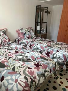 a bedroom with a bed with a floral comforter at Maison de ville rénovée in Senonches