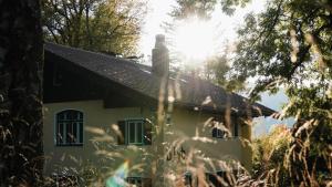 a white house with a black roof and trees at Blyb Hotel in Gmund am Tegernsee