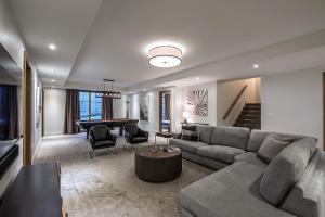 Una sala de estar con un sofá y una mesa de billar. en Havre Des Skieurs 111 Luxurious & Modern Direct Ski-in Ski-out, en Mont-Tremblant