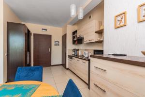 a kitchen and dining room with a table and chairs at Lazurowy Dwór - Królewski Sen by Grand Apartments in Sztutowo
