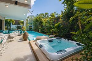 a hot tub on a patio next to a swimming pool at Villa Ayana - Premium Mauritius Stay in Grand Baie