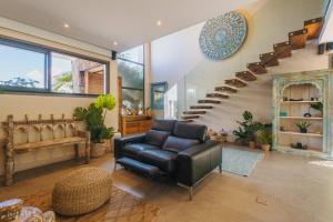 a living room with a chair and a staircase at Villa Ayana - Premium Mauritius Stay in Grand Baie
