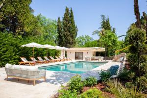 a swimming pool with lounge chairs and umbrellas at Villa Lily of the valley in Mougins