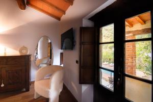 a room with a mirror and a chair and a window at Il Mulino di Nonna Sà - Prestige Private Villa in Pietrasanta