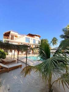 a resort with a pool and palm trees and a building at Mexhe Hotel El Cuyo in El Cuyo