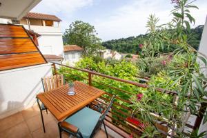 a balcony with a wooden table and chairs at Apartments Ardura in Petrovac na Moru
