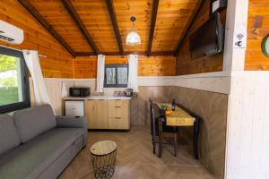 uma sala de estar com um sofá e uma mesa em בקתות עץ מעל העננים - אירוח דרוזי - בקתות כפריות עם נוף מהמם ובריכה מחוממת מקורה משותפת em Beit Jann
