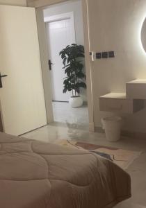 a bedroom with a bed and a potted plant at مادير 1 in Jeddah +35 photos
