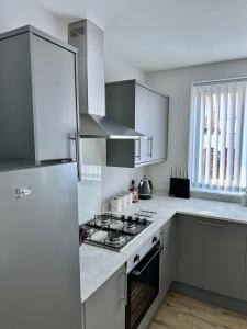 una cocina con estufa y refrigerador en Beautifully Spacious 3 Bed Home, en Kenton 11 fotos más