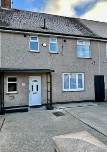 una casa de ladrillo con puerta blanca y entrada en Beautifully Spacious 3 Bed Home, en Kenton