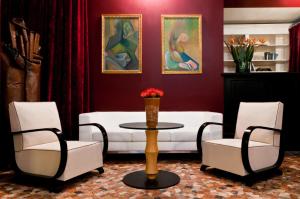 ヴィチェンツァにあるAntico Hotel Vicenzaのリビングルーム(白いソファ、椅子2脚、テーブル付)