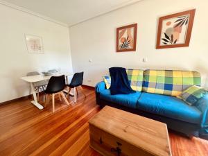 a living room with a blue couch and a table at Circobueno de Isla - 5609 in Arnuero