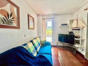 a living room with a blue couch and a tv at Circobueno de Isla - 5609 in Arnuero