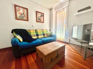a living room with a blue couch and a tv at Circobueno de Isla - 5609 in Arnuero