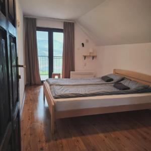a bedroom with a bed and a large window at Vila Zapis Zavojsko jezero in Pirot