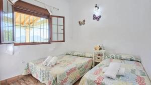 Un dormitorio con dos camas y una ventana. en Luxurious Villa in Prado del Rey with Pool, en Prado del Rey
