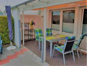 a patio with a table and chairs on a patio at Friesenkate Bensersiel in Esens