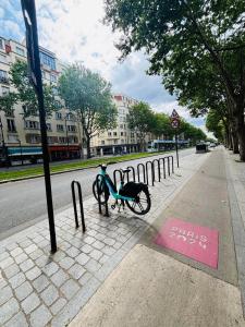 a bike parked on a sidewalk next to a street at Appartement Porte d'Orléans Paris in Paris +12 photos