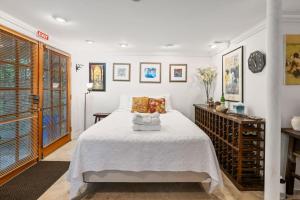a white bedroom with a bed and a table at La Petite Fleur-Charming Park Circle Private Studio in Charleston