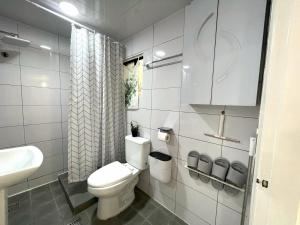 a white bathroom with a toilet and a sink at Stay In Itaewon in Seoul +31 photos