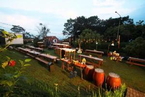 a group of picnic tables and benches in a park at Hotel Amanda Hills Bandungan in Bandungan
