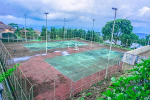 a tennis court with a net on a tennis court at Hotel Amanda Hills Bandungan in Bandungan