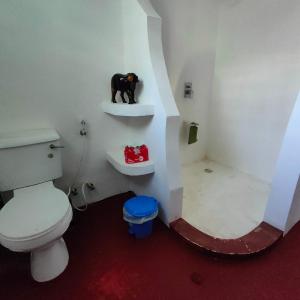 Baba Yaga Nest Beach Farm House في Gatunga: حمام مع مرحاض وتمثال كلب أسود