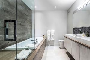 Un baño con bañera, inodoro y lavabo. en Havre 115 Des Montagnes Luxurious & Modern Ski-in Ski-out, en Mont-Tremblant 34 fotos más