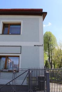 a white building with a fence in front of it at Przytulny apartament 2 in Żywiec