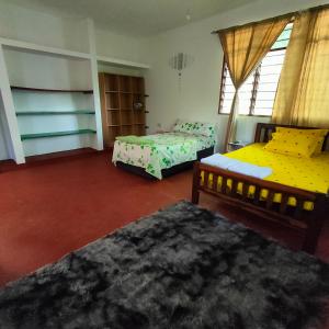 Baba Yaga Nest Beach Farm House في Gatunga: غرفة نوم بها سريرين ونافذة