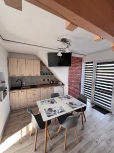 a kitchen with a dining room table and chairs at Słoneczny Domek in Grywałd